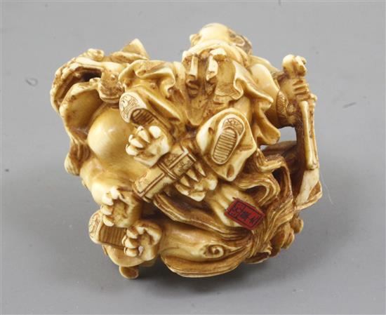 A Japanese ivory okimono of two boys with a Buddhist lion, Meiji period, height 5cm